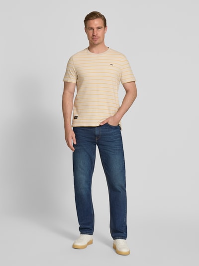 Mannelijk model draagt T-Shirt met Streifenmuster und Logo van camel active, regular fit, zuiver katoen, ronde hals, geel met witte strepen, voorkant volledig zichtbaar, opname van voren.