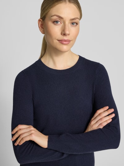 Modelka kobieca nosi Slim Fit Strickpullover aus reinem Kaschmir od Christian Berg Woman, krój slim fit, z czystego kaszmiru, elastyczne wykończenia, długość tyłu 54 cm, długość rękawa 65 cm, ciemnogranatowy kolor, prosta faktura, zbliżenie górnej części ciała.