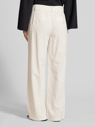Frauenmodel trägt Wide-Leg-Pants aus Viskose-Mix mit Eingrifftaschen von FREE/QUENT in Creme mit schwarzen Punkten, Leinen-Viskose-Mix, Gesäßleistentaschen, Modell Anya, Ganzkörperansicht Rückansicht.