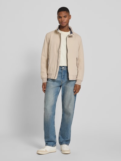 Männermodel trägt Regular Fit Blouson mit Stehkragen von Tom Tailor in Beige, unifarben, langer Ärmel, Twill, Ganzkörperansicht von vorne.