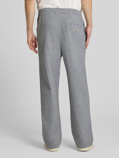 Männermodel trägt Track Pants mit Logo-Stitching Modell 'Skagen' von Pegador aus Reine Baumwolle, Loose-Fit, Grau, Gesäßleistentasche, Ganzkörperansicht Rückansicht.
