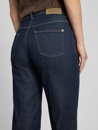 Frauenmodel trägt Wide Fit Jeans mit 5-Pocket-Design von MAC, dunkelblauer Baumwoll-Mix, lockerer Schnitt, Detailaufnahme Rückansicht.