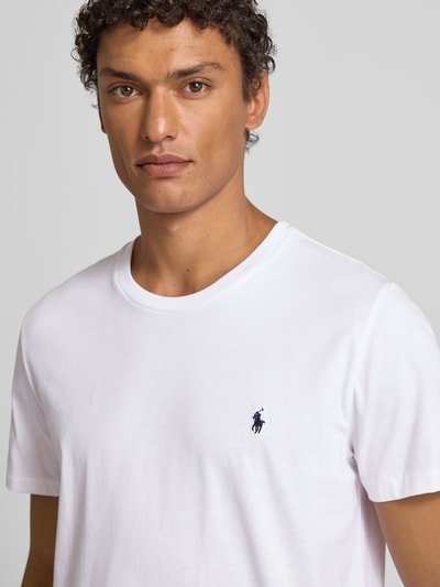 Männermodel trägt T-Shirt mit Logo-Stitching von Polo Ralph Lauren aus reiner Baumwolle, gerade Passform, Rundhalsausschnitt, Nahaufnahme Oberkörper.