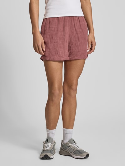 Männermodel trägt Relaxed Fit Shorts aus reiner Baumwolle Modell 'THYRA' von Only, unifarben, elastischer Bund, crêpe Textur, seitliche Taschen, Ganzkörperansicht von vorne