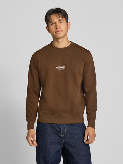 Männermodel trägt Regular Fit Sweatshirt aus katoenmix Model 'Soho' von JACK & JONES met logoprint, ronde hals, elastische boordjes, kleur bruin, Ganzkörperansicht von vorne