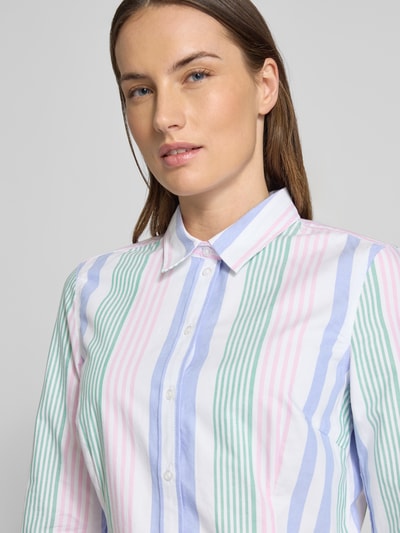 Vrouwenmodel draagt Slim Fit Hemdbluse mit Sportmanschetten van Christian Berg Woman, katoen, getailleerde fit, pastel strepen, close-up bovenlichaam.