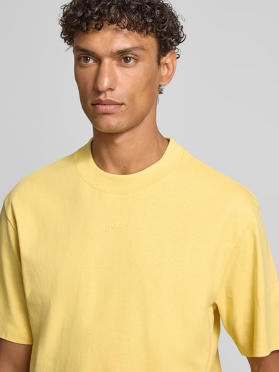 Männermodel trägt Regular Fit T-Shirt aus reiner Baumwolle Modell 'DAPOLINO' von HUGO in Gelb, Optik: Unifarben, Label-Schriftzug, Jersey, Nahaufnahme Oberkörper.