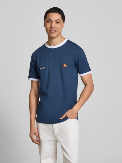 Męski model nosi T-Shirt mit Logo- und Label-Patch Modell 'RINGETTO' od Ellesse, czysta bawełna, krój regular fit, widok z przodu, zdjęcie całej sylwetki.