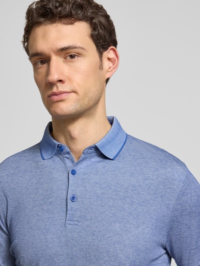 Männermodel trägt Slim Fit Poloshirt mit Label-Detail von HECHTER PARIS, blaue Baumwollmischung, glatte Textur, Nahaufnahme Oberkörper.