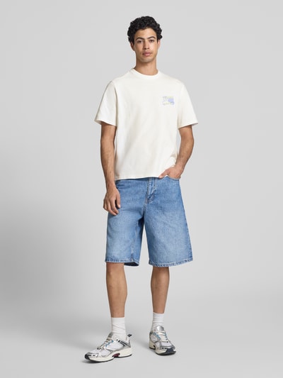 Mannenmodel draagt Regular Fit T-shirt uit zuiver katoen model '90s van Tommy Jeans, look: effen, labelprint, ronde hals, korte mouw, jersey materiaalverwerking, kleur wit, geheel vooraanzicht.