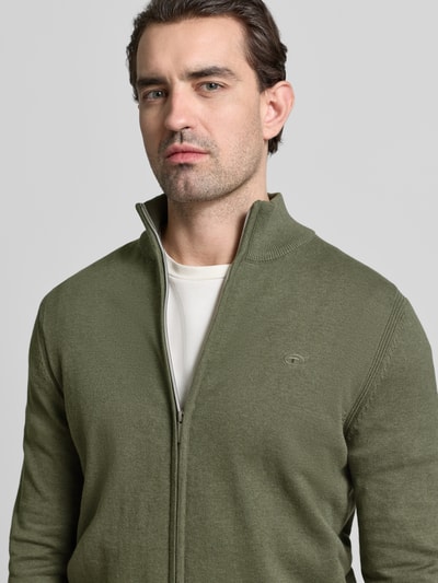 Męski model nosi Regular Fit Strickjacke aus reiner Baumwolle von Tom Tailor, zielony, jednolity, stójka, długi rękaw, dzianina, logo, krój regular fit, bawełna, zbliżenie górnej części ciała.