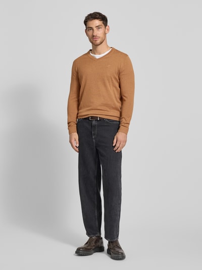 Männermodel trägt Regular Fit Strickpullover aus reiner Baumwolle von Tom Tailor in Melange-Optik mit V-Ausschnitt, Ganzkörperansicht von vorne.
