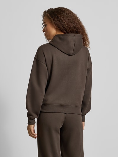 Frauenmodel trägt Regular Fit Hoodie aus Baumwoll-Mix Modell 'BEST' von ONLY in Dunkelbraun, glatte Oberfläche, Ganzkörperansicht Rückansicht. Damen Hoodie von ONLY