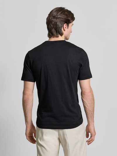 Männermodel trägt T-Shirt mit Label-Schriftzug Modell 'DULIVIO' von HUGO, schwarz, reine Baumwolle, Unifarben, Ganzkörperansicht Rückansicht.