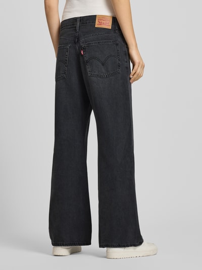 Kobiece modelka nosi czarne Loose Fit Jeans z kieszeniami, model 'MIDDY LOOSE BOOT' od Levi's®, widok całej sylwetki z tyłu.