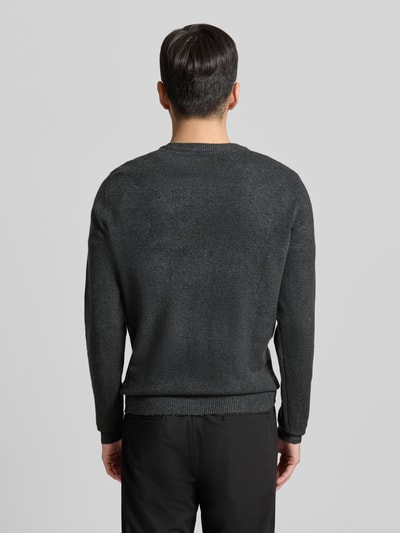Männermodel trägt Strickjacke mit Knopfleiste Modell 'HEINE' von Casual Friday in Dunkelgrau, gerippte Abschlüsse, Ganzkörperansicht Rückansicht.