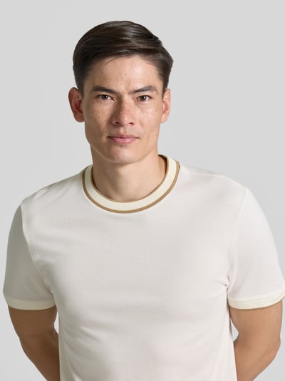 Männermodel trägt Regular Fit T-Shirt aus reiner Baumwolle Modell 'H-THOMPSON 81' von BOSS, cremefarben mit Kontrastbündchen, Nahaufnahme Oberkörper, Herren T-Shirt.