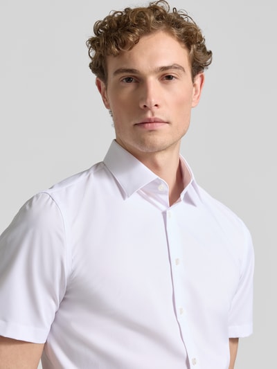 Männermodel trägt Slim Fit Business-Hemd mit Kentkragen von Jake*s, Elastischer-Material-Mix, Kurzärmelig, Weiß, Nahaufnahme Oberkörper.