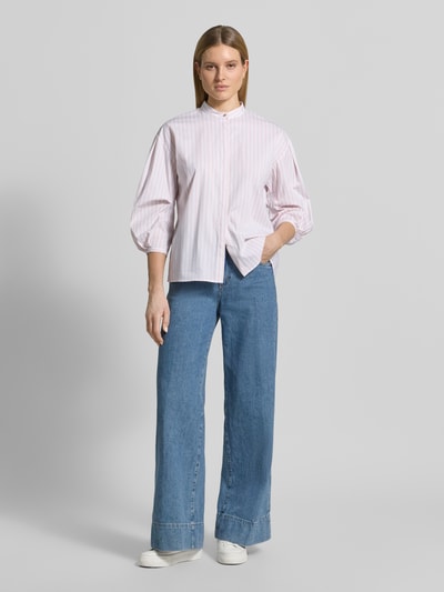 Frauenmodel trägt Regular Fit Langarmbluse aus Baumwoll-Mix Modell 'Badrani' von JOOP!, gestreift in Rosa und Weiß, Stehkragen mit Knopfverschluss, durchgehende Knopfleiste mit Abdeckleiste, 3/4-Ballonärmel, Rückenlänge 65 cm, Ärmellänge 52 cm, Ganzkörperansicht von vorne.