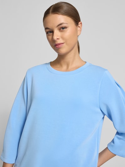 Frauenmodel trägt Comfort Fit Sweatshirt aus Modal-Mix von s.Oliver RED LABEL in Hellblau, unifarben, 3/4-Arm, Nahaufnahme Oberkörper.