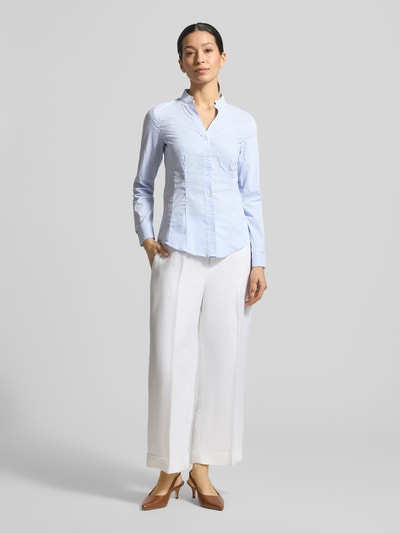 Frauenmodel trägt Slim Fit Bluse mit Stehkragen und V-Ausschnitt von More & More aus Baumwoll-Mix mit Stretch-Anteil, Ganzkörperansicht von vorne.