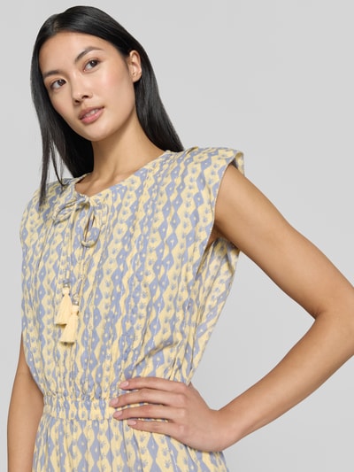 Vrouwenmodel draagt Maxikleid mit Schlüsselloch-Ausschnitt und Bindung van Scotch & Soda in katoenmix, getailleerd model, kapmouwen, druppelvormige hals met striksluiting, volantzoom, ruglengte maat 36: 144 cm, borstwijdte maat 36: 41 cm, lichtgele en lila patronen, eenvoudige structuur. Nahaufnahme bovenlichaam.