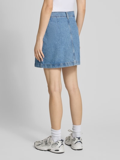 Frauenmodel trägt Schmaler Jeansrock aus reiner Baumwolle Modell 'AMAZING' von Only in hellem Denim mit Kontrastnähten, Ganzkörperansicht Rückansicht.
