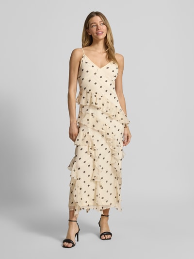 Modelka kobieca ma na sobie Figurbetontes Midikleid mit Rüschen Modell 'SMILLA' od Vero Moda, kremowe w czarne grochy, szyfon, długość midi, widok całej sylwetki z przodu.