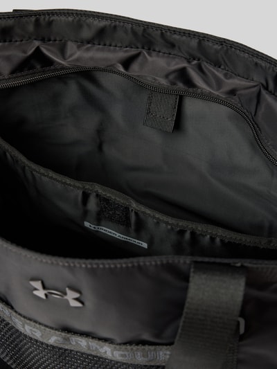 Productfoto, zwarte shopper met logodetail van Under Armour, ruime opening, zichtbare rits, gladde textuur, dames