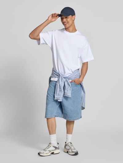 Männermodel trägt Herren T-Shirt mit Rundhalsausschnitt Modell 'BARRON' von Jack & Jones aus Baumwoll-Mix mit Stretch-Anteil, Relaxed-Fit, Rückenlänge bei Größe M 73 cm, Farbtöne Weiß und Hellblau, Ganzkörperansicht von vorne.