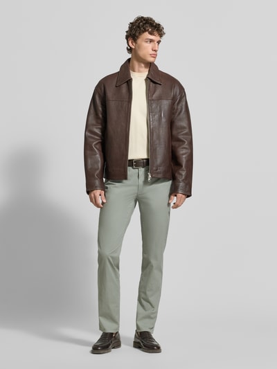 Männermodel trägt unifarbene Regular fit Hose mit 5-Pocket-Design aus katoenmix Modell 'Cadiz' von Brax, Ganzkörperansicht von vorne.