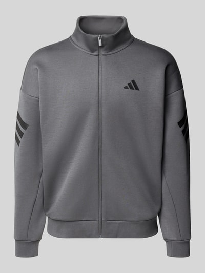 Produktfoto, Sweatjacke mit Logo und Reißverschluss von adidas Sportswear in Grau, Baumwoll-Mix, Regular Fit, Stehkragen, sichtbarer Reißverschluss.