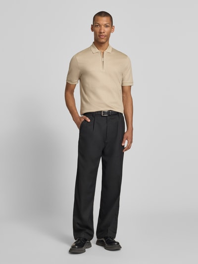 Männermodel trägt Regular Fit Poloshirt aus Baumwoll-Lyocell-Mix Modell 'H-PARAS 70' von BOSS in Beige, unifarben, Ganzkörperansicht von vorne.