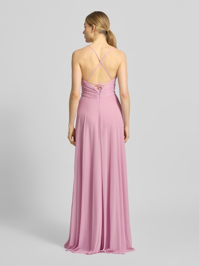 Vrouwenmodel draagt avondjurk met rugzijde gekruiste spaghettibandjes van Jake*s Cocktail in roze chiffon, a-lijn, maxi-jurk, geplooid, v-hals, ruglengte bij maat 36: 126 cm, borstwijdte 38 cm, met vetersluiting en haak- en ritssluiting, volledige achteraanzicht.