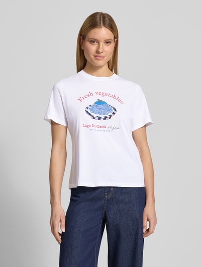 Modelka kobieca nosi Regular Fit T-Shirt mit Logo-Print od Lanius z bawełny, okrągły dekolt, długość tyłu 58 cm w rozmiarze 36, przód całej sylwetki.