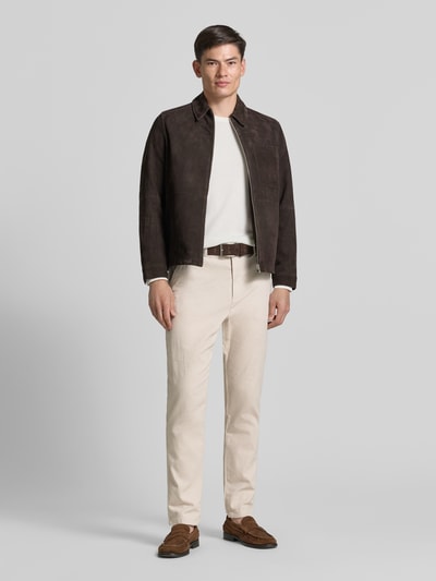 Męski model nosi Regular Fit Chino aus Baumwoll-Mix od Tom Tailor, kolor melanż, z paskiem, widok całej sylwetki z przodu.