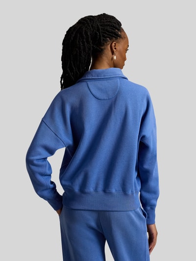 Frauenmodel trägt Sweatshirt mit Label-Stitching von Polo Ralph Lauren in Blau mit Polokragen, gerippten Abschlüssen, Ganzkörperansicht Rückansicht.