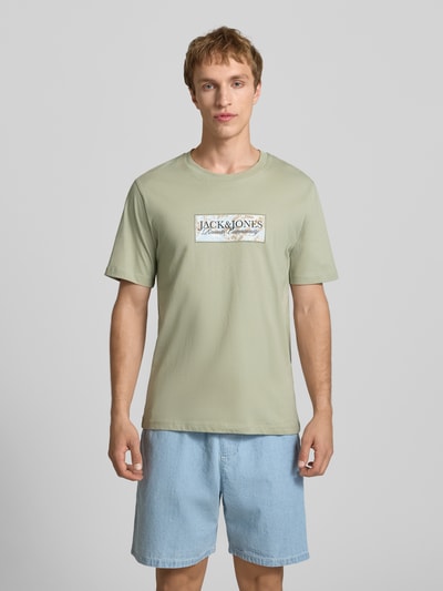 Männermodel trägt T-Shirt mit Label-Print von Jack & Jones in hellem Grün, Reine Baumwolle, Gerader-Schnitt, Rundhalsausschnitt, Ganzkörperansicht von vorne.