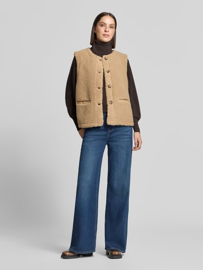 Vrouwenmodel draagt bodywarmer van Teddybont Model 'Eddy' van FREE/QUENT, regular fit, paspelzakken, kleur beige, frontaal volledig zicht, ruglengte maat S 58 cm, schouderbreedte 38 cm, borstwijdte 51 cm.