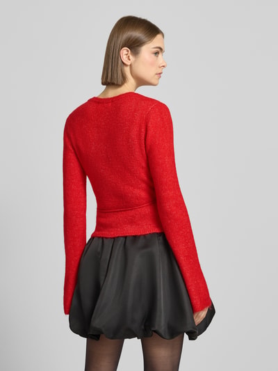 Frauenmodel trägt Cardigan in Wickel-Optik von Gina Tricot in Rot, Material-Mix mit Alpaka-Anteil, Slim-Fit, Ganzkörperansicht Rückansicht.