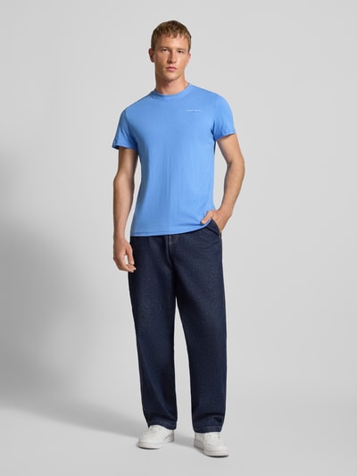 Männermodel trägt Slim Fit T-Shirt aus reiner Baumwolle von Tommy Jeans, Optik: Unifarben, Label-Print, Rundhals, Kurzarm, Ganzkörperansicht von vorne.