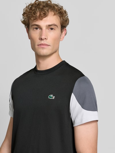 Männermodel trägt Regular Fit Sport-T-Shirt im Colorblock-Design von Lacoste, Schwarz, Grau und Weiß, Herren Sport-T-Shirt, Nahaufnahme Oberkörper.