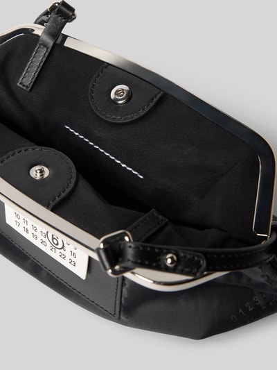 Produktfoto, Pochette mit Magnetverschluss von MM6 Maison Margiela mit Hauptfach, Label-Patch und Motiv-Print, glattes schwarzes Design, Maße ca. 25 cm Breite, 20 cm Länge, 9 cm Tiefe, verstellbarer Schulterriemen.