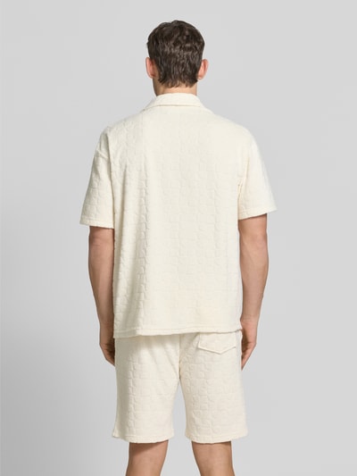 Männermodel trägt Regular Fit Freizeithemd mit Strukturmuster von MCNEAL in Creme, sichtbare Knopfleiste und Reverskragen, Ganzkörperansicht Rückansicht. Baumwoll-Mix, lockerer Schnitt, kurze Ärmel, strukturierte Oberfläche, Rückenlänge 74 cm, Schulterbreite 40 cm, Ärmellänge 25 cm.