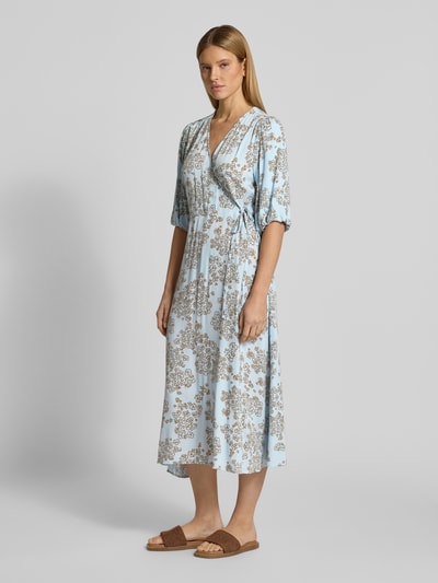 Modelka kobieca nosi Midikleid aus Viskose in Wickel-Optik mit 1/2-Arm od JAKE*S STUDIO WOMAN, jasnoniebieskie w beżowy wzór, czysta wiskoza, krój taliowany, dekolt w serek, długość tyłu w rozmiarze 36: 124 cm, szerokość w rozmiarze 36: 55 cm, długość rękawa w rozmiarze 36: 41 cm, widok całej sylwetki z przodu.