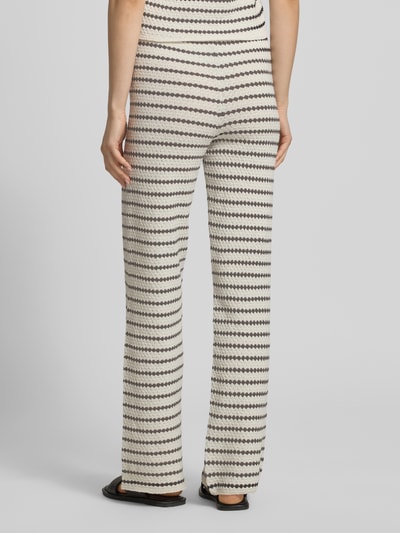 Frauenmodel trägt Strickhose in Streifen-Optik mit elastischem Bund von REVIEW, Material-Mix mit Baumwoll-Anteil, Flared Cut, Ganzkörperansicht Rückansicht.