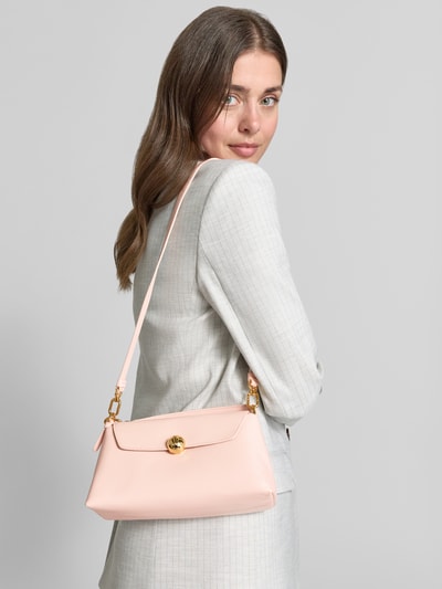 Frauenmodel trägt Umhängetasche mit Label-Detail Modell 'SFERA' von FURLA in zartem Rosa, rechteckige Form, glatte Textur, Ganzkörperansicht Rückansicht. Umschlag mit Druckknopf, verstellbarer Schultergurt, Maße 23x14x9 cm, Riemenlänge 110 cm.