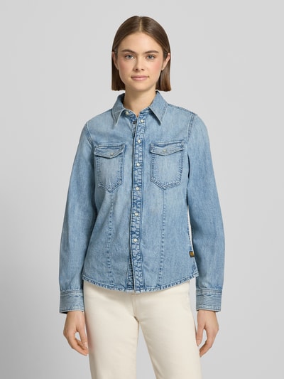 Frauenmodel trägt Slim Fit Jeanshemd mit Brusttaschen von G-Star in heller Waschung aus reiner Baumwolle, Hemdblusenkragen, Knopfleiste, Ganzkörperansicht von vorne.