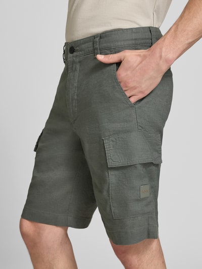 Männermodel trägt Relaxed Fit Cargoshorts aus Leinen-Mix Modell 'SISLA-CARGO-S1' von BOSS Orange, Optik: Unifarben, Label-Schriftzug, seitliche Eingrifftaschen und Cargotaschen, Popeline Materialverarbeitung, Ganzkörperansicht von vorne.