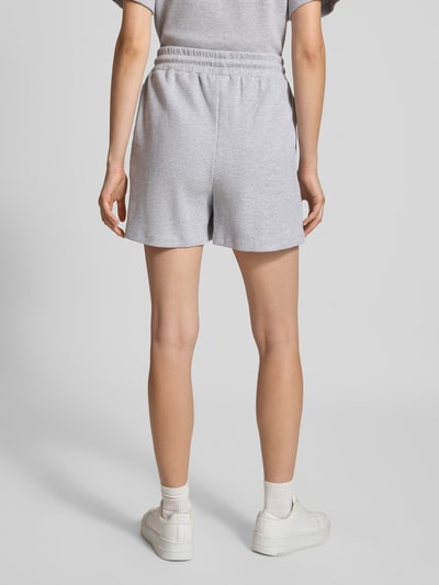 Vrouwenmodel draagt Shorts met structuurpatroon Model 'Elow' van OH APRIL van puur katoen met regular fit, elastische band, tunnelkoord, bandwijdte maat S 39 cm, binnenbeenlengte maat S 9 cm, grijs, structuuroppervlak, volledige lichaamsaanzicht achteraan.